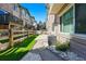 A fenced backyard with artificial turf, a stone pathway, and access to a small deck area at 12925 Grant Cir # A, Thornton, CO 80241