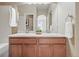 Bathroom featuring double sinks with a tiled backsplash, a large mirror, and white towels at 12925 Grant Cir # A, Thornton, CO 80241