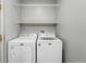 Practical laundry room with a white washer and dryer set, with shelf above at 12925 Grant Cir # A, Thornton, CO 80241