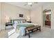 Carpeted main bedroom with a large bed frame, bedside tables, and an ensuite bathroom through an arched doorway at 12925 Grant Cir # A, Thornton, CO 80241