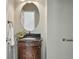 Elegant powder room boasts a stylish vanity with a granite countertop and a decorative oval mirror at 12925 Grant Cir # A, Thornton, CO 80241