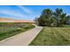 Scenic community walking path bordered by natural grass, trees, and a privacy wall at 12925 Grant Cir # A, Thornton, CO 80241