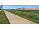 Wide, paved walking path surrounded by natural grasses and fencing in the community at 12925 Grant Cir # A, Thornton, CO 80241