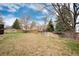 View of the backyard featuring a wooden fence and mature trees at 1296 Ascot Ave, Highlands Ranch, CO 80126