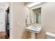 Classic half-bathroom featuring a pedestal sink, mirror, and toilet at 1296 Ascot Ave, Highlands Ranch, CO 80126