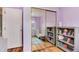 Bedroom featuring a view of a crib and bookshelf through a mirrored closet, a rug, and purple walls at 1296 Ascot Ave, Highlands Ranch, CO 80126