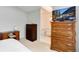Bright bedroom with a TV and furniture leading to a well-lit bathroom with white tile flooring and modern fixtures at 1296 Ascot Ave, Highlands Ranch, CO 80126
