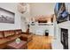 Cozy living room with fireplace, open staircase, and connection to the kitchen at 1296 Ascot Ave, Highlands Ranch, CO 80126