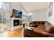 Bright living room with high ceilings, fireplace, and comfortable leather sectional at 1296 Ascot Ave, Highlands Ranch, CO 80126