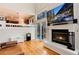 Spacious living room with fireplace, glass doors, and view to dining area at 1296 Ascot Ave, Highlands Ranch, CO 80126
