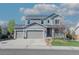 Charming two-story home with a three car garage, well-manicured lawn, and inviting front porch at 7665 Grady Cir, Castle Rock, CO 80108