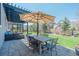 Outdoor patio with a dining table under an umbrella, surrounded by green space at 7665 Grady Cir, Castle Rock, CO 80108