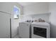 Bright laundry room with new washer and dryer, shelving, and a window at 14268 Hop Clover Trl, Parker, CO 80134