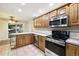 Kitchen with wood cabinets, stainless steel appliances, and tiled floor at 2695 S Ammons Way, Lakewood, CO 80227