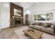 Virtually staged living room with stone fireplace and large windows at 2695 S Ammons Way, Lakewood, CO 80227