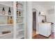 Open shelving with wine rack and glassware next to the compact kitchen with butcher block countertop at 4712 Perry St, Denver, CO 80212