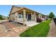 Beautiful home exterior featuring a covered deck and a landscaped backyard with green grass at 7426 E 148Th Pl, Thornton, CO 80602