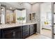 Bathroom with double sinks, granite countertops, and dark wood cabinetry, offering a view into the bedroom at 7426 E 148Th Pl, Thornton, CO 80602