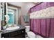 Bathroom with a single sink vanity, toilet, and shower with a patterned purple shower curtain at 7426 E 148Th Pl, Thornton, CO 80602