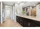 Elegant bathroom featuring double sinks, granite countertops, dark wood cabinetry, and a separate glass shower at 7426 E 148Th Pl, Thornton, CO 80602