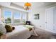 Sun-lit bedroom features three large windows, a chandelier, and a cozy seating area at 7426 E 148Th Pl, Thornton, CO 80602