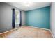 This bedroom has gray and teal walls, neutral carpet, a window, and simple light fixture at 7426 E 148Th Pl, Thornton, CO 80602