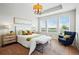 Bright bedroom featuring a chandelier, a tray ceiling, and three windows offering abundant natural light at 7426 E 148Th Pl, Thornton, CO 80602