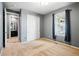 A bedroom with gray walls, neutral carpet, double sliding door closet, and an ensuite bathroom at 7426 E 148Th Pl, Thornton, CO 80602