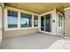 Cozy covered deck featuring wood flooring, large windows, and a sliding glass door at 7426 E 148Th Pl, Thornton, CO 80602