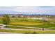 Picturesque golf course view with a pond, surrounding houses, and snow-capped mountains in the background at 7426 E 148Th Pl, Thornton, CO 80602