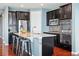 Beautiful kitchen island with dark cabinets, granite countertops, bar stool seating, and modern appliances at 7426 E 148Th Pl, Thornton, CO 80602