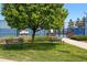 Peaceful park area with benches beneath a mature shade tree and sports courts in the background at 7426 E 148Th Pl, Thornton, CO 80602