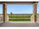 Inviting covered porch with wood flooring, decorative pillars, and a view of the green lawn at 7426 E 148Th Pl, Thornton, CO 80602