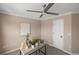 Neutral bedroom with a modern ceiling fan, desk with décor, and white door at 10606 Cottoneaster Way, Parker, CO 80134