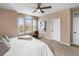 A bright bedroom with neutral paint, a large arched window, a ceiling fan, and a chair at 10606 Cottoneaster Way, Parker, CO 80134