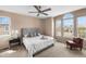 A bright bedroom with neutral paint, a large window, a ceiling fan, and a well-dressed bed at 10606 Cottoneaster Way, Parker, CO 80134