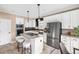 Bright kitchen featuring white cabinets, stainless steel appliances, and a central island with bar seating at 10606 Cottoneaster Way, Parker, CO 80134