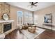 Bright living room featuring a stone fireplace, three large windows, and hardwood floors at 10606 Cottoneaster Way, Parker, CO 80134