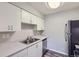 A kitchen with white cabinets, grey countertops, stainless sink and a stainless steel refrigerator at 14437 E 1St Dr # C09, Aurora, CO 80011