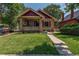 Brick home with a charming front porch and well-manicured lawn at 3560 N Columbine St, Denver, CO 80205