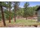 Wooded backyard with mature trees and a wooden bridge, view from upper level at 94 Spring Ln, Boulder, CO 80302