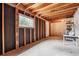 Unfinished basement area with concrete floor, wood framing, and a single window at 94 Spring Ln, Boulder, CO 80302