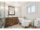 Bright bathroom featuring soaker tub, standalone vanity with wood mirror, and neutral tiling at 94 Spring Ln, Boulder, CO 80302