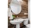 Charming bathroom features wood accent wall, oval mirror, and pedestal sink at 94 Spring Ln, Boulder, CO 80302