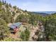 Aerial view of a home nestled in a wooded area, showcasing its natural surroundings and spacious layout at 94 Spring Ln, Boulder, CO 80302