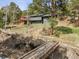 View of the house with a wooden bridge, a deck and wooded backyard at 94 Spring Ln, Boulder, CO 80302