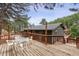 Enjoy the expansive wooden deck, perfect for outdoor dining and gatherings in a serene, wooded setting at 94 Spring Ln, Boulder, CO 80302