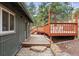 The exterior showcases a wooden deck and stone pathway, surrounded by lush greenery, blending seamlessly with nature at 94 Spring Ln, Boulder, CO 80302