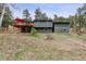 Back view of the house with a deck and wooded backyard at 94 Spring Ln, Boulder, CO 80302