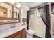 Full bathroom with tile tub and shower, toilet and sink with cabinet at 11123 Clermont Dr, Thornton, CO 80233